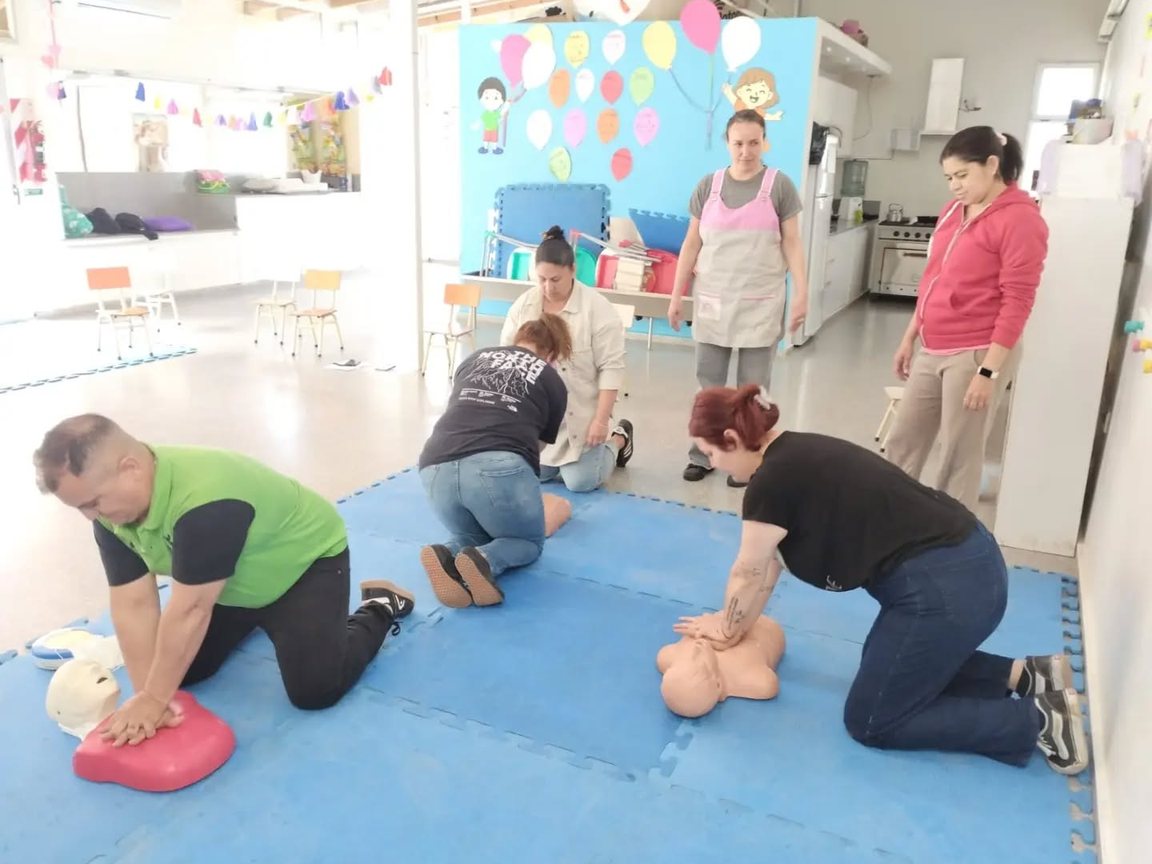Un instructor del CODE y una participante practican la reanimación con muñecos sobre las colchonetas del CDI María Elena Walsh