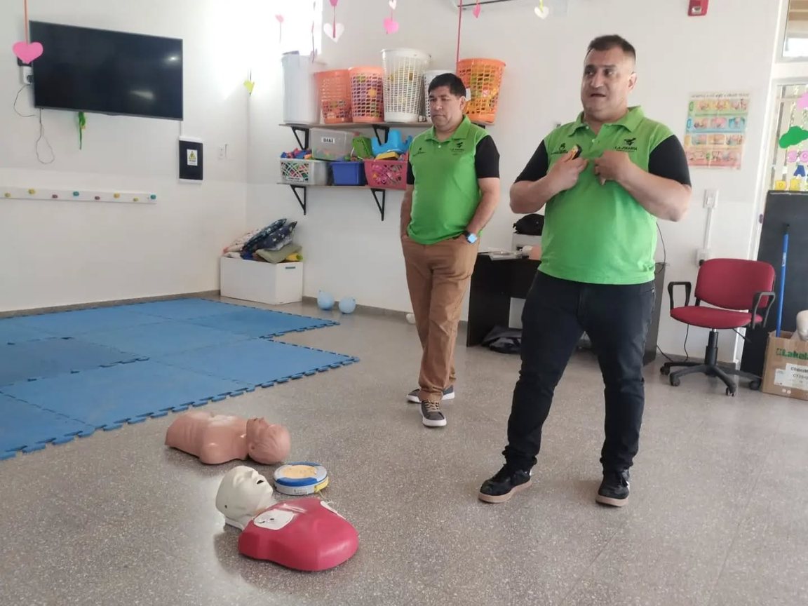 Los instructores del CODE explican la capacitación en una sala del CDI, con los muñecos de práctica en el piso
