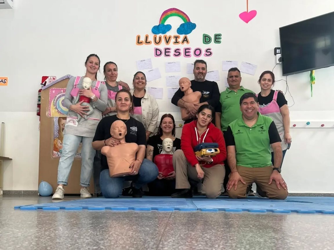 Foto grupal de los instructores del CODE con las familias y las educadoras del CDI, con los muñecos de práctica