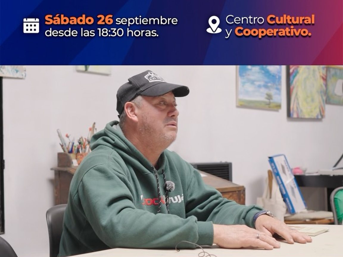 Portada del video de invitación al conversatorio: un hombre con gorra, sentado a una mesa en una sala con cuadros en las paredes