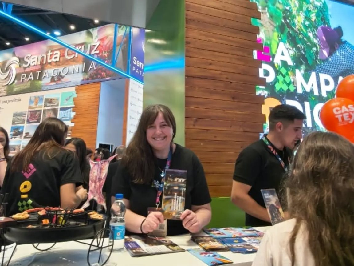 Atención al público en el stand de La Pampa Original en la FIT, con folletos sobre la mesa