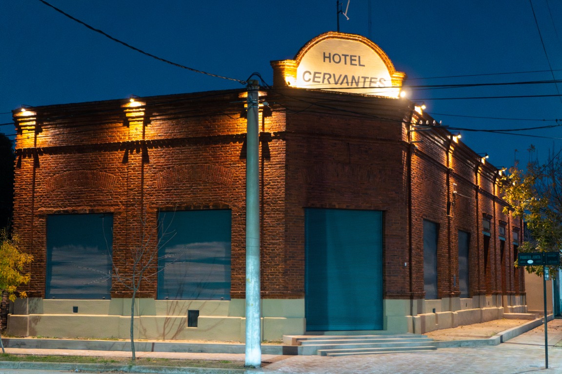 El Hotel Cervantes iluminado, con su cartel en la fachada