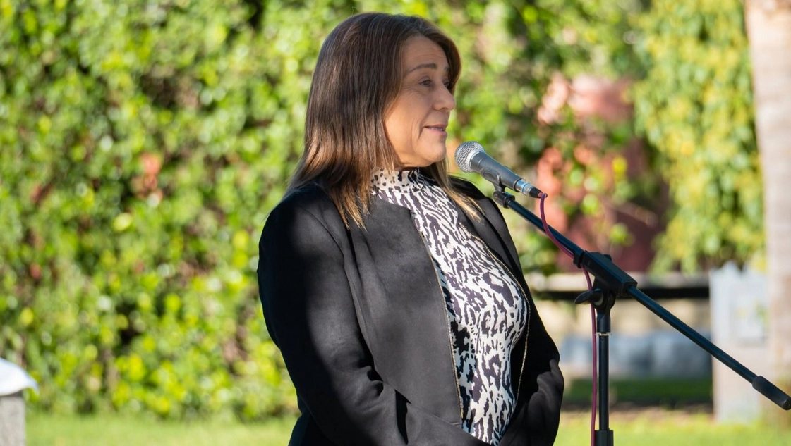 Irma Adriana García, intendenta de Winifreda, hablando ante un micrófono en un acto al aire libre