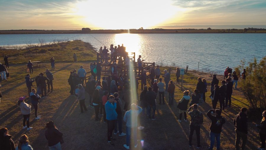 Atardecer en la Laguna Luan Lauquen, con visitantes a contraluz sobre el mirador del sendero de acceso