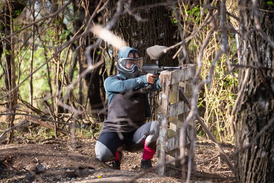 Jugador de paintball apuntando desde una barricada en el circuito instalado en el predio del Vivero