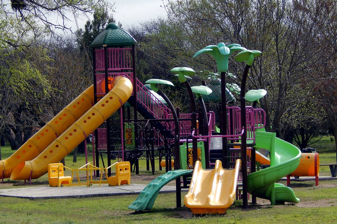 Juegos infantiles con toboganes de colores en el Paseo de las Vías, el antiguo entorno ferroviario de Winifreda
