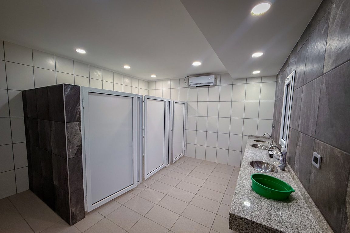 Sector de baños renovado en el Parque Recreativo Evita, con nuevos boxes y bacha de mármol